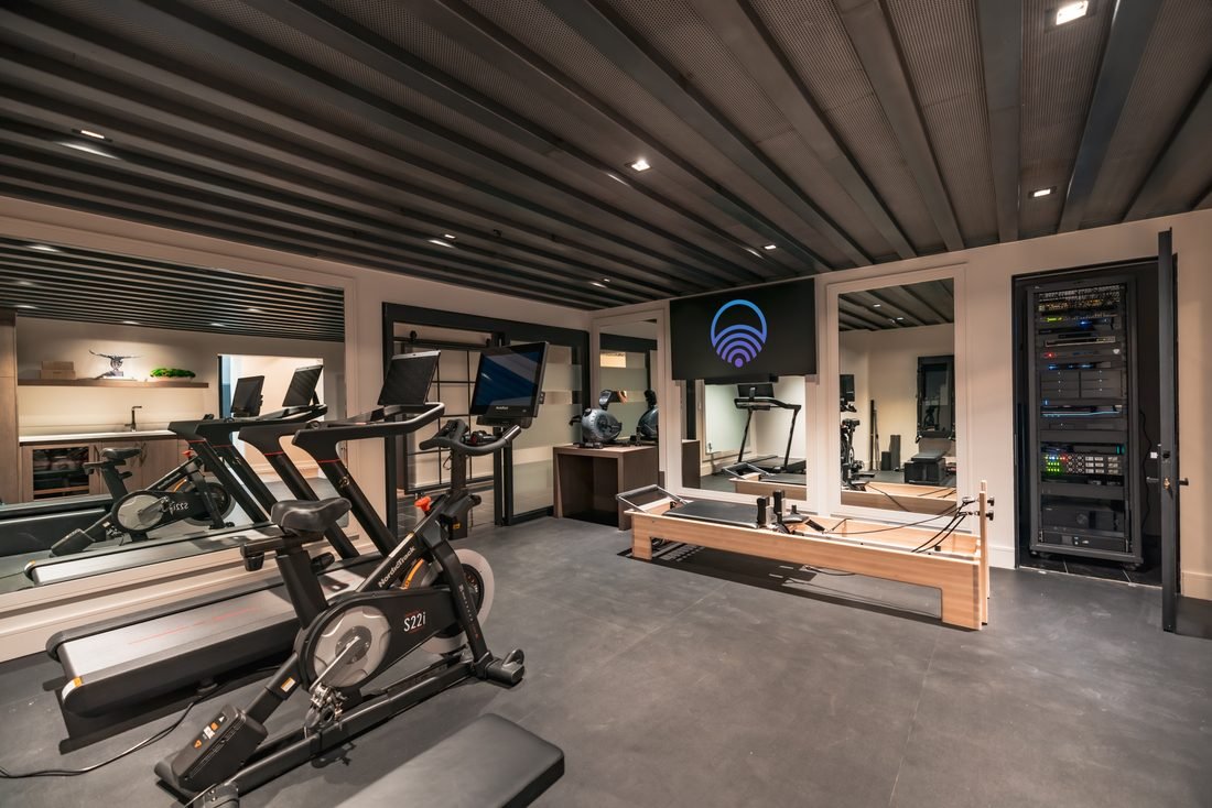 Home gym with bikes, a treadmill and a reformer