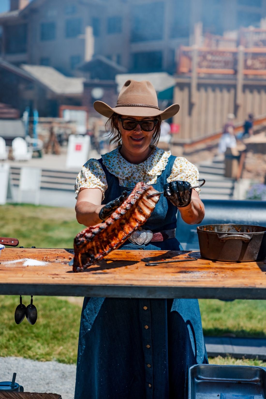 Cook lifting a rack of ribs at an outdoor event